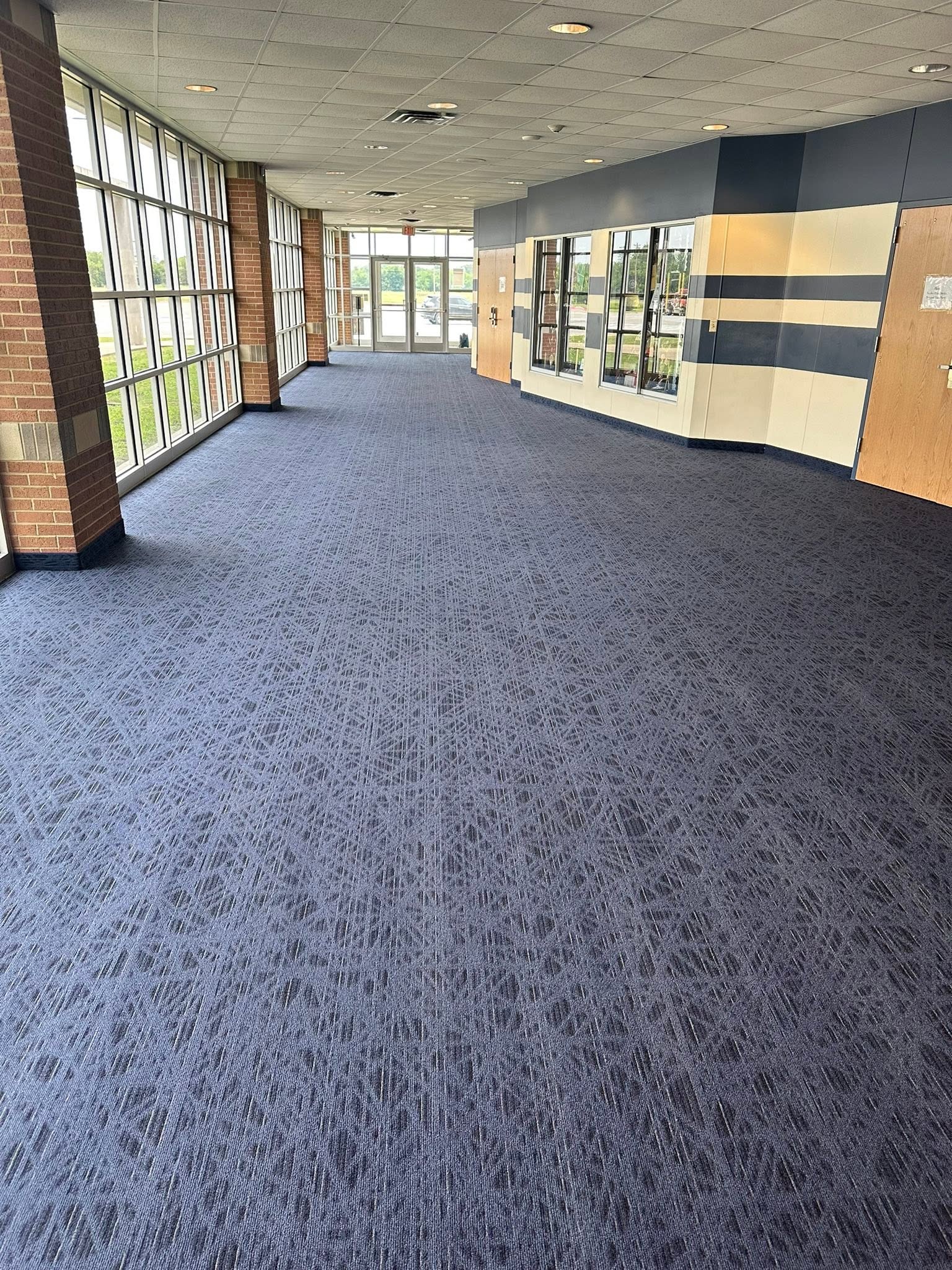 Quinlan ISD hallway showing freshly cleaned blue carpet after professional hot-water extraction