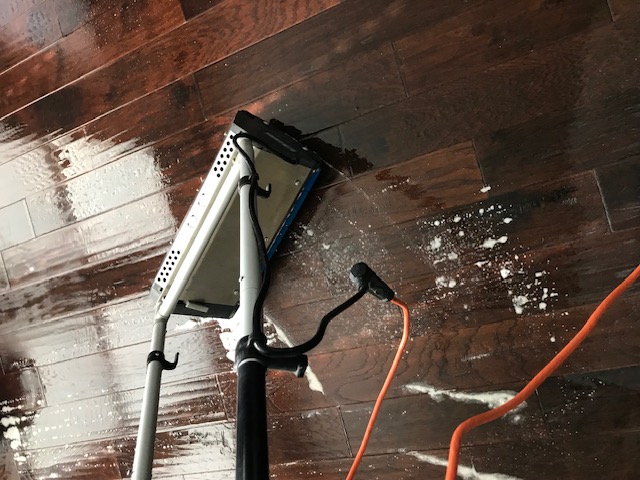 Dark hardwood floor being professionally cleaned with rotary equipment in Greenville, TX — Bulldog Carpet Cleaning
