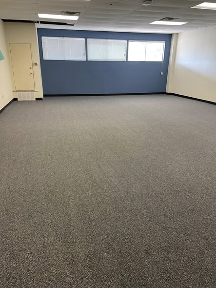 Quinlan ISD office room with air mover drying carpet after professional cleaning